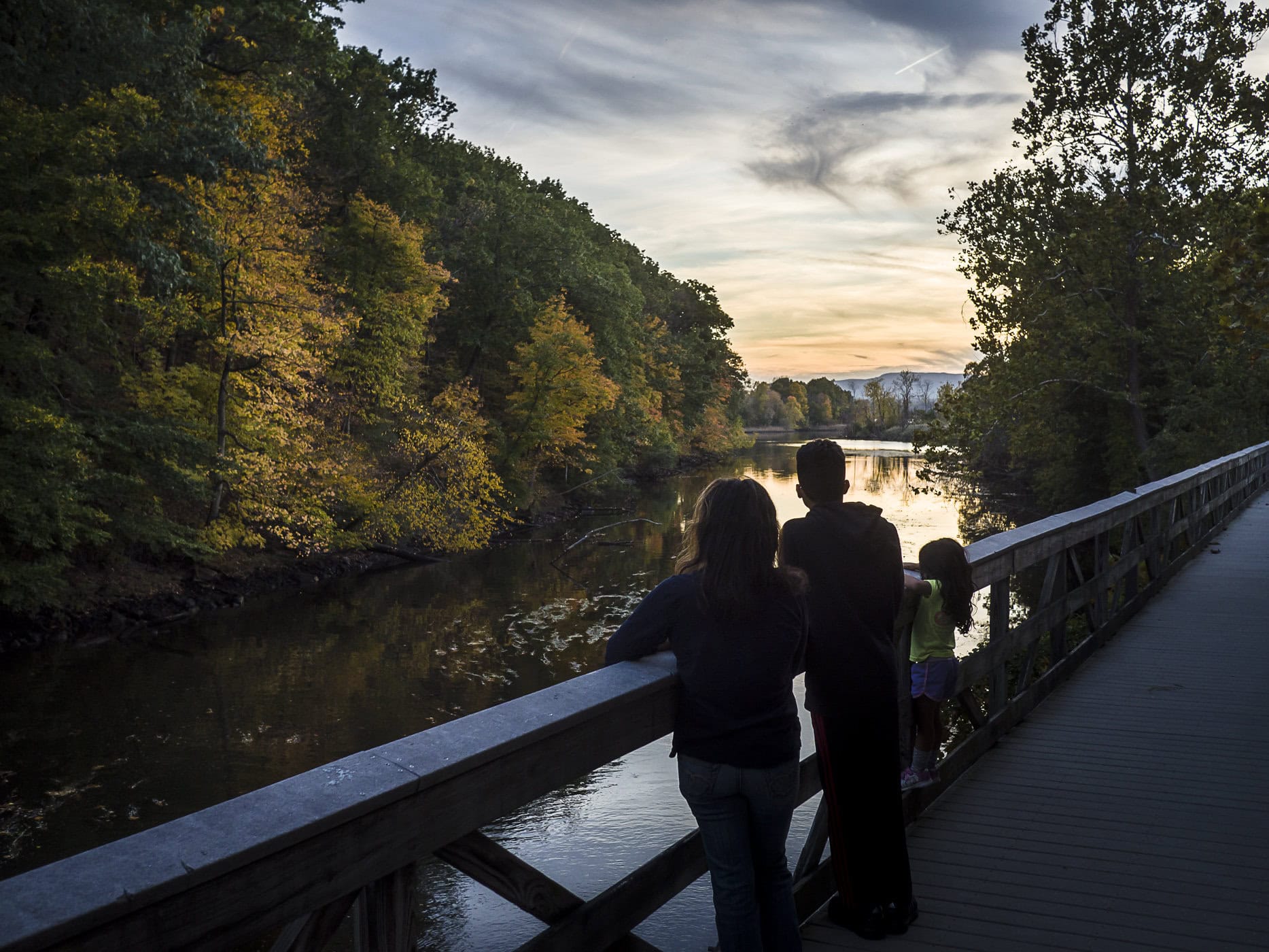 A group of people on the boardwalk at sunset looking out over the water in Madam Brett Park. Photo: Robert Rodriguez Jr.
