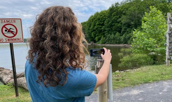 Taking a picture of shoreline erosion at a community science chronology station. (Image: Jo-Anne Asuncion)